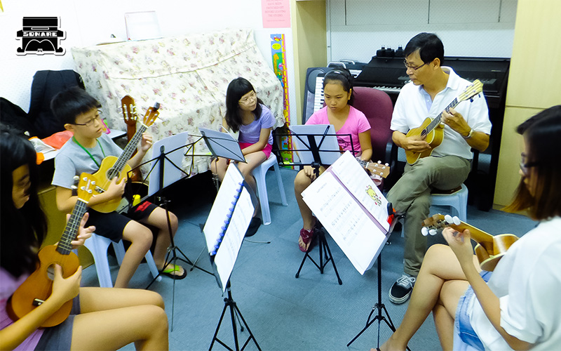 Sonare Music School students playing guitar on stage.