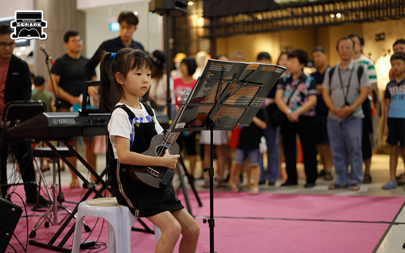 Sonare student performing ukulele at a live music showcase.
