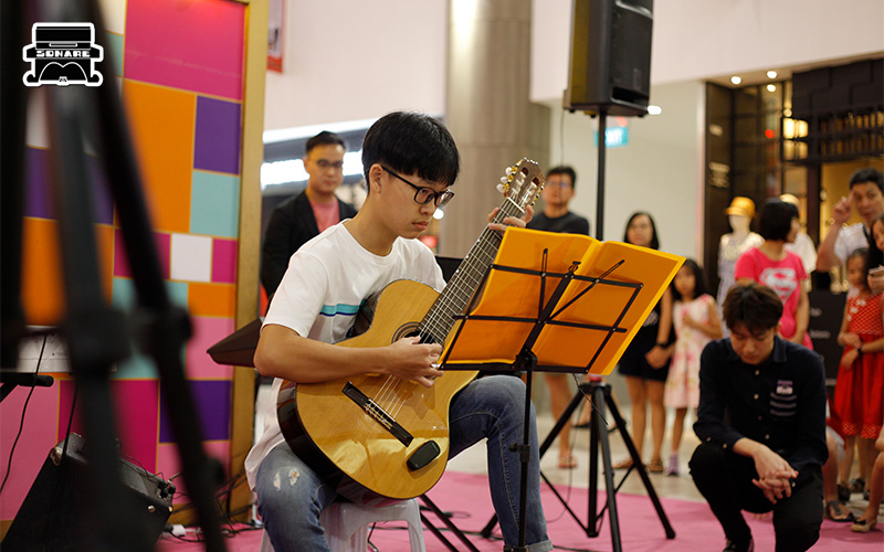 Sonare student playing classical guitar at a beginner performance.