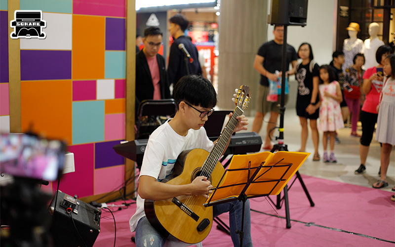 Teen boy playing an acoustic guitar at Sonare Music.