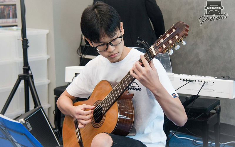 Student practicing guitar rhythm to strengthen early thinking skills.