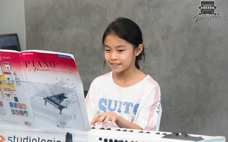 Young girl playing piano to build early thinking skills