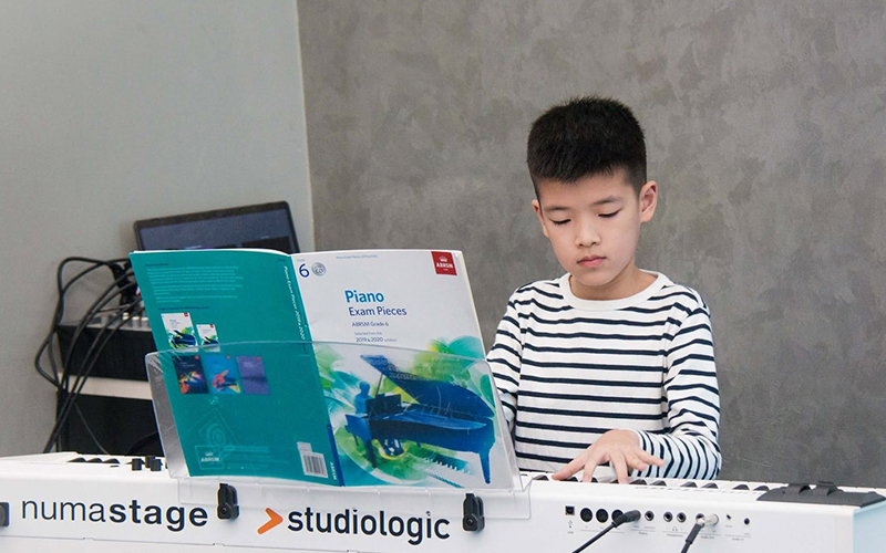 Young boy playing keyboard during a trial music lesson.