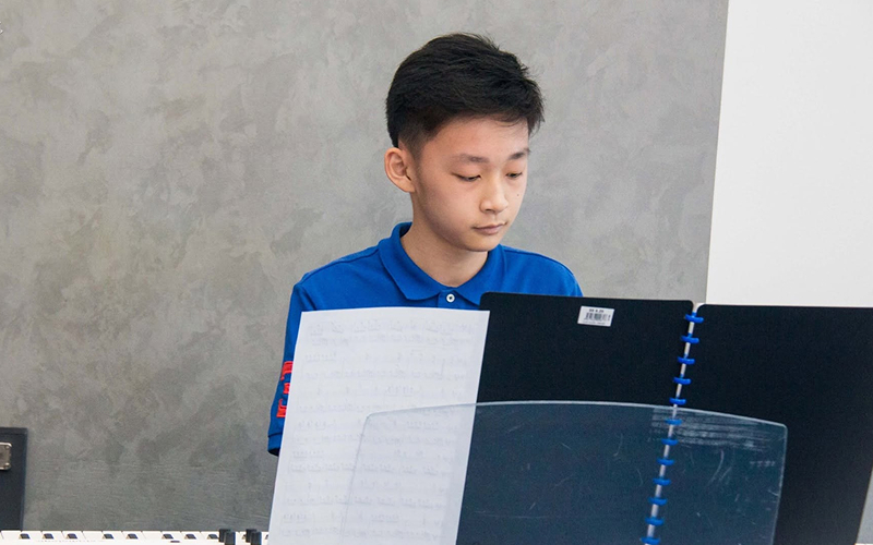 Student reading sheet music in a trial music class.
